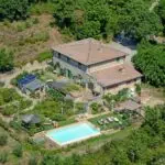 aerial view of farmhouse, pool and gardens