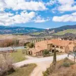 View of large Tuscan farmhouse villa and land